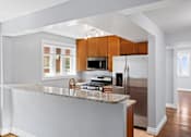 Thumbnail 13 of 15 - a kitchen with wood cabinets and a granite counter top